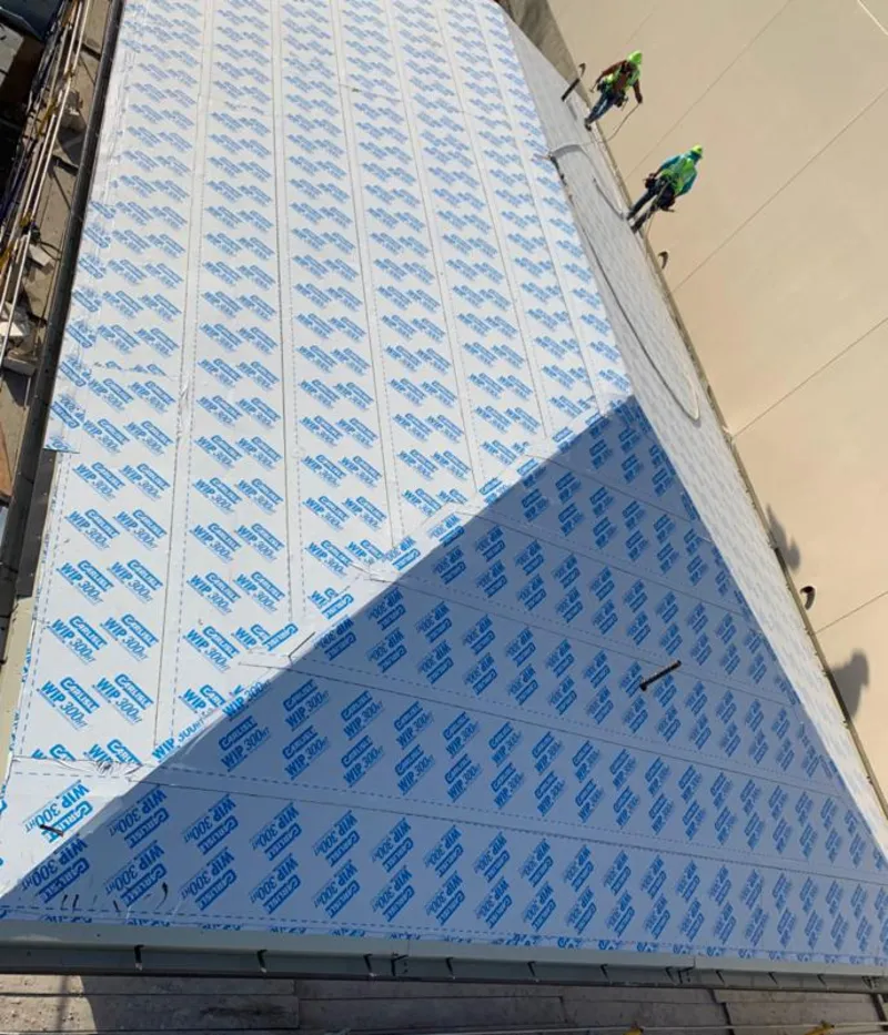 Professional roofers installing underlayment on a metal roof in Sudbury